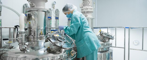 Ouvrière d&#39;une usine pharmaceutique dans une chaîne de production de vêtements de protection en milieu stérile