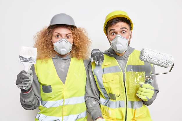 Des ouvriers d'entretien expérimentés et choqués peignent un appartement occupé à des travaux de rénovation, de réparation et de redécoration.