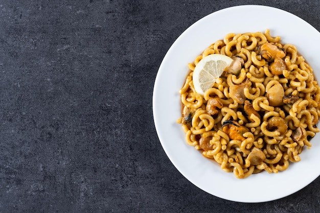 Photo gratuite paella espagnole traditionnelle de nouilles de fideua sur le fond noir