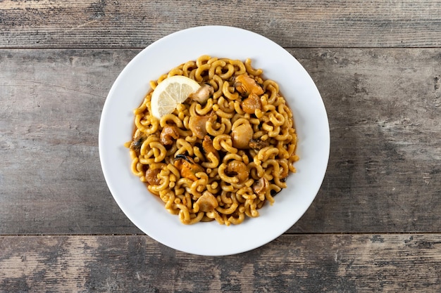 Photo gratuite paella espagnole traditionnelle de nouilles de fideua sur la table en bois