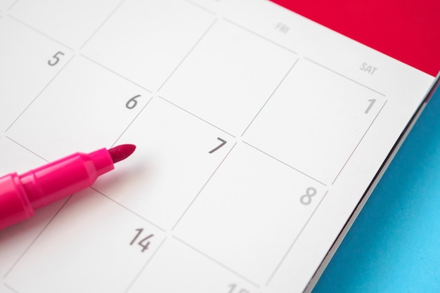 Page de calendrier avec stylo gros plan sur fond bleu concept de réunion de rendez-vous de planification d'entreprise