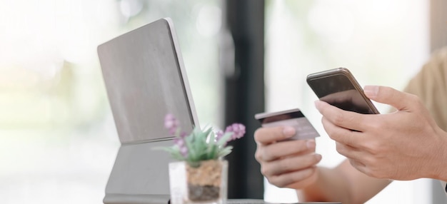Paiement en ligne, mains de l'homme tenant une carte de crédit et utilisant un smartphone et choisissez un produit qu'il veut pour les achats en ligne.