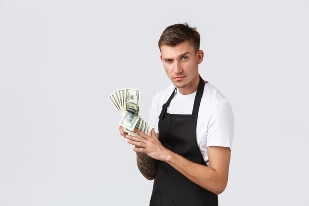 Les paiements et les employés des petites entreprises de détail concept effronté beau vendeur propriétaire de café comptant dans ...