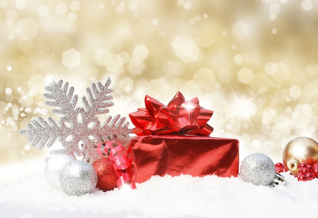 Pailleté or fond de Noël avec des décorations dans la neige
