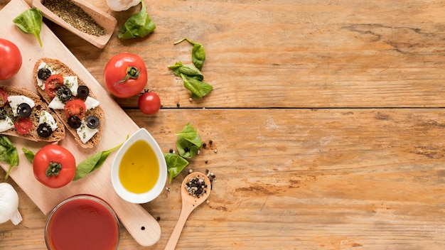 Pain au four avec garniture et légumes sur une planche à découper