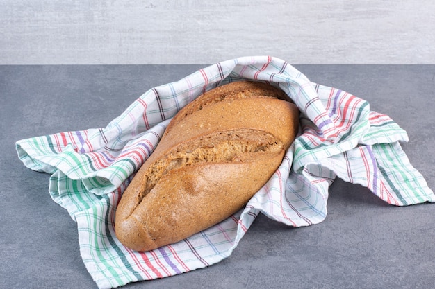 Pain De Bâton Enveloppant Dans Une Serviette Sur Du Marbre.