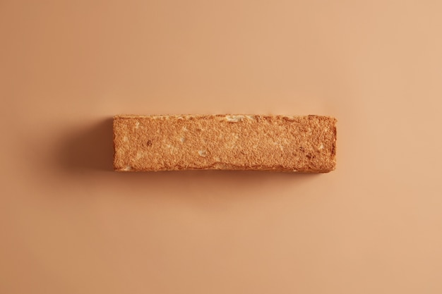 Pain de blé croustillant fait maison phototographié d'en haut. Fond beige. Concept de boulangerie et de nourriture. Produit comestible biologique avec beaucoup de glucides. Alimentation saine. Copiez l'espace pour votre promo