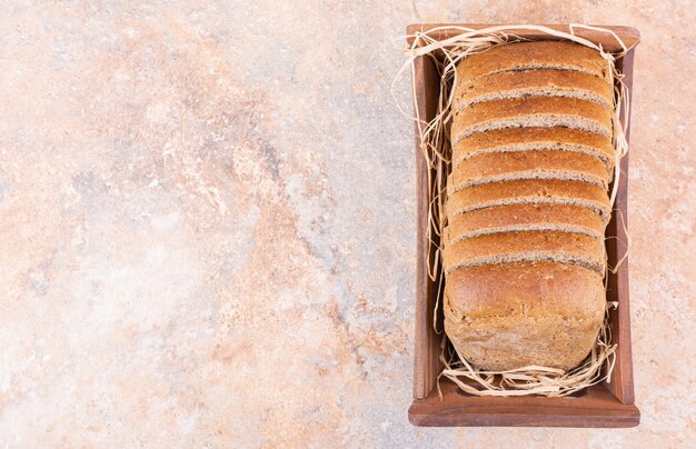 Pain de blé dans une boîte, sur la table en marbre.