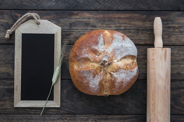 Photo gratuite pain entre le rouleau à pâtisserie et le tableau noir