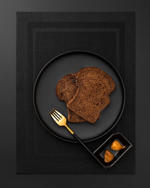 Pain grillé sur une assiette sombre sur un drap noir