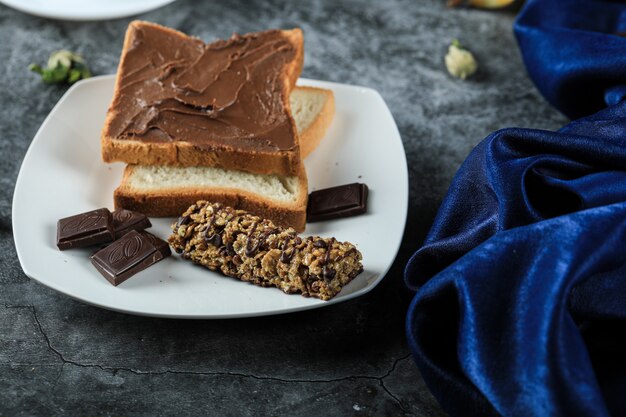 Pain grillé au chocolat avec des morceaux de chocolat dans une soucoupe blanche