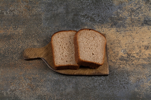 Photo gratuite pain grillé noir sur planche de bois