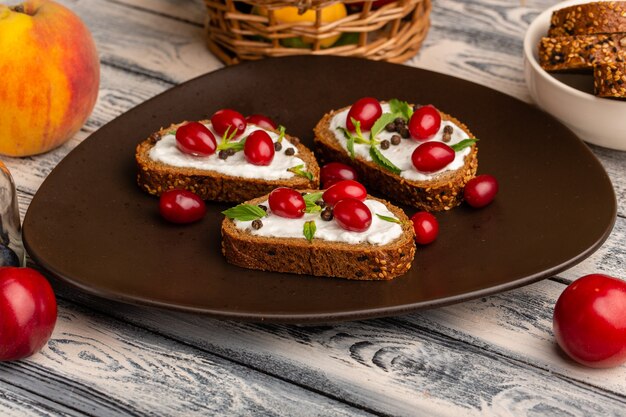 Pain avec des miches de pain à la crème à l'intérieur de la plaque brune sur fond gris