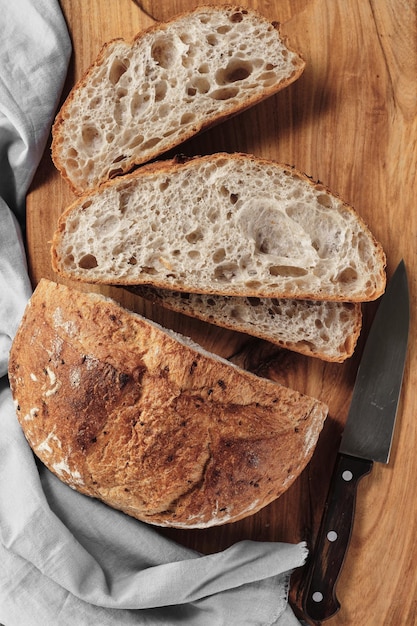 Pain tranché de pain au levain artisanal sur une planche à découper Cadre vertical vue de dessus