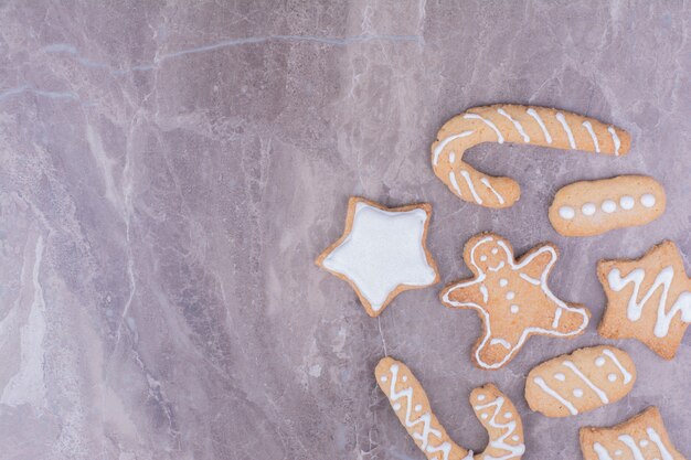 Pains d'épices de Noël de différentes formes sur la surface de la pierre