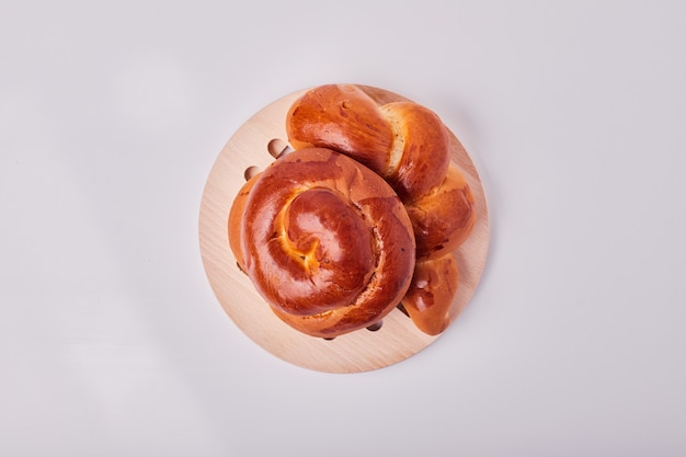 Pains de pâtisserie de style caucasien sur un plateau en bois, vue de dessus.