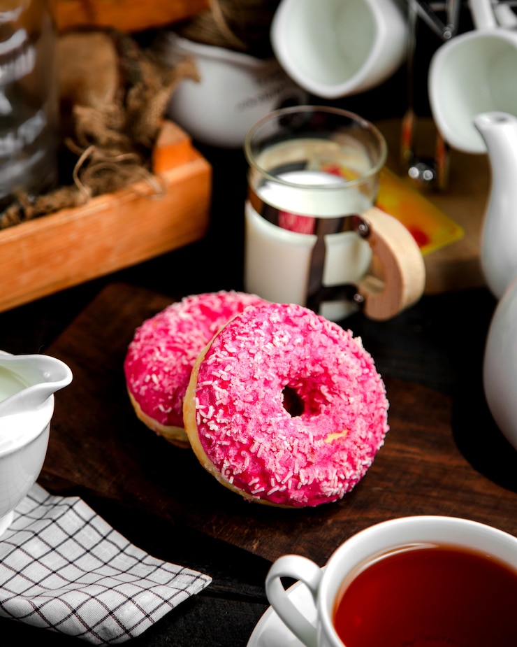 Photo gratuit une paire de beignets à la crème rose et aux bonbons