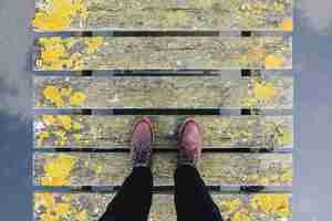 Photo gratuite paire de chaussures en cuir marron debout sur un vieux pont gris et jaune