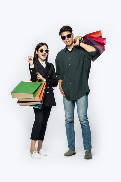 Une paire d'homme et de femme portant des lunettes et transportait beaucoup de sacs en papier pour faire du shopping