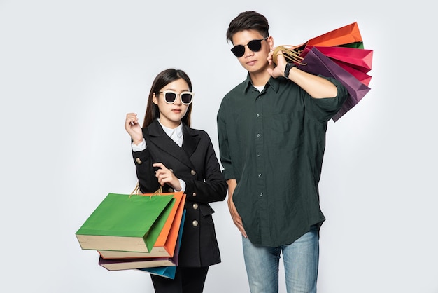 Une paire d'homme et de femme portant des lunettes et transportait beaucoup de sacs en papier pour faire du shopping