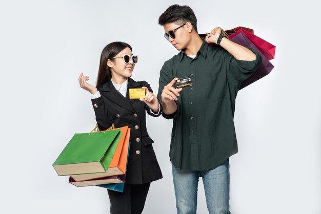 Une paire d'homme et de femme portant des lunettes et transportait beaucoup de sacs en papier pour faire du shopping