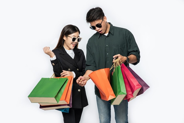 Une paire d'homme et de femme portant des lunettes et transportait beaucoup de sacs en papier pour faire du shopping