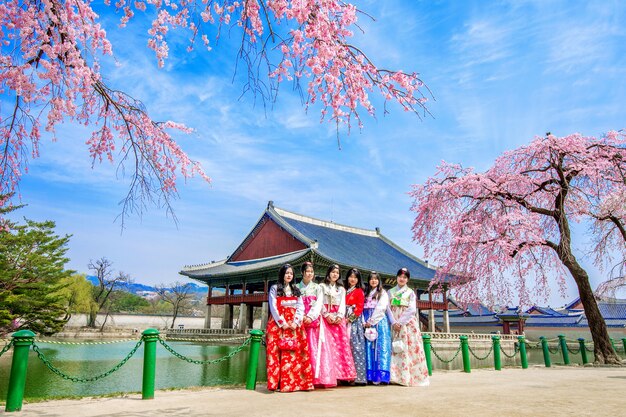 Palais Gyeongbokgung avec fleur de cerisier au printemps et touristes avec robe Hanbok