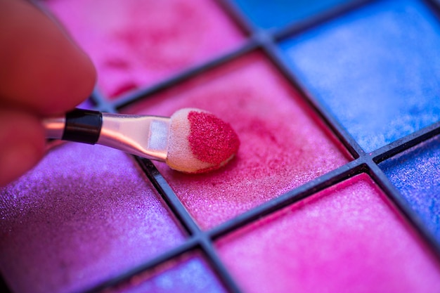 Palette colorée pour le maquillage avec la main tenant le pinceau