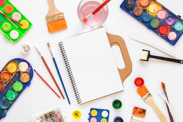 Palette de couleurs dans des boîtes et cahier vide