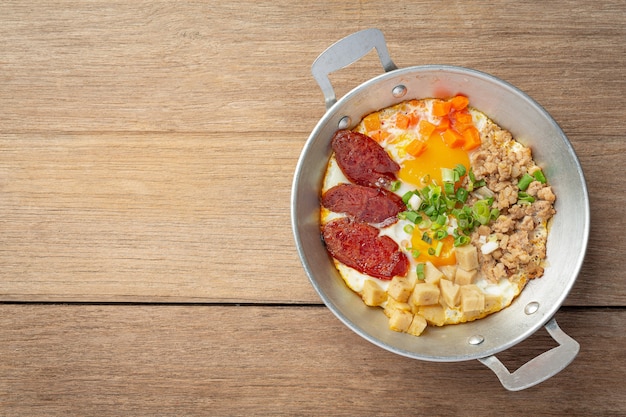 Pan oeufs saupoudrés de saucisse chinoise, bacon en dés, petit déjeuner.