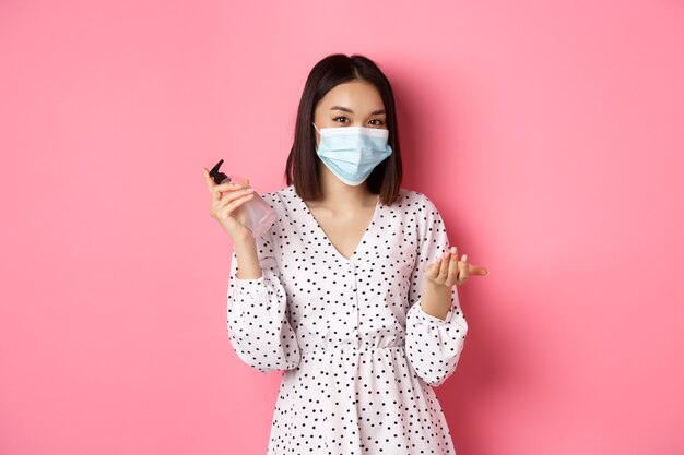 Pandémie de covid et concept de mode de vie jolie femme asiatique se nettoyer les mains avec un désinfectant à l'aide d'un antiseptique et d'un antiseptique.
