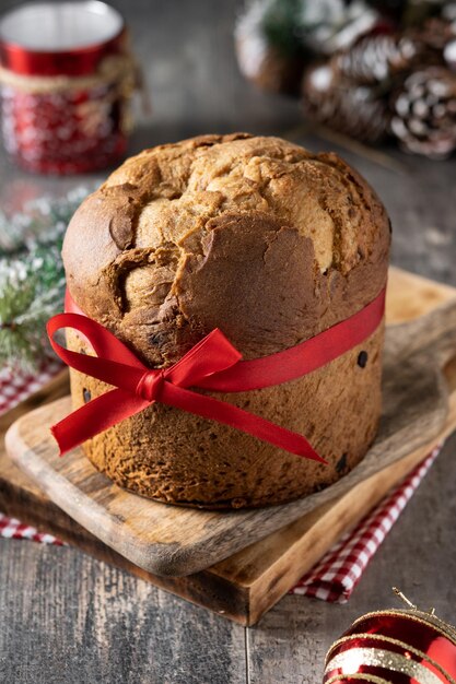 Panettone de Noël traditionnel avec cravate rouge sur table en bois