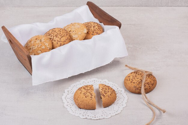 Panier de biscuits aux graines de sésame sur une surface blanche.