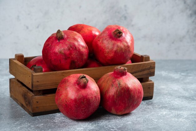 Un panier en bois plein de fruits de grenade mûrs sucrés.