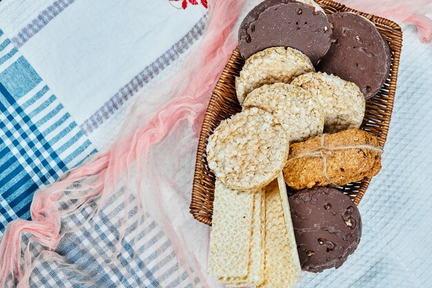 Un panier de divers biscuits sur une nappe. Vue de dessus.