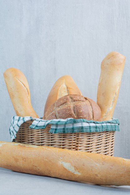 Panier de divers pains sur fond de marbre. Photo de haute qualité