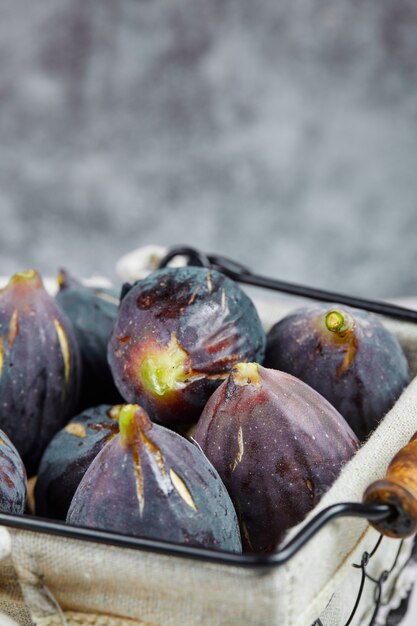 Un panier de figues violettes sur marbre.