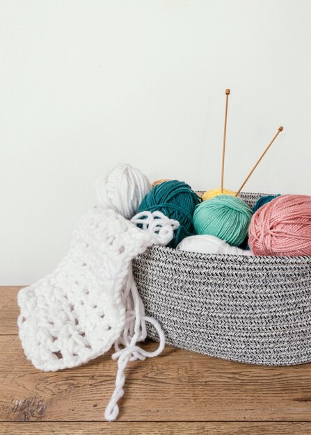 Panier avec de la laine et des aiguilles à tricoter