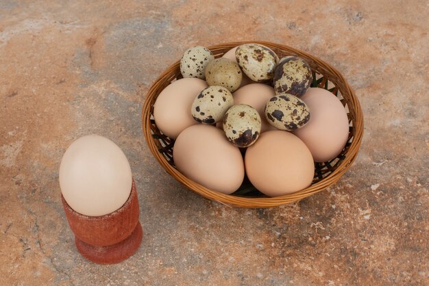 Panier d'oeufs blancs sur table en marbre.