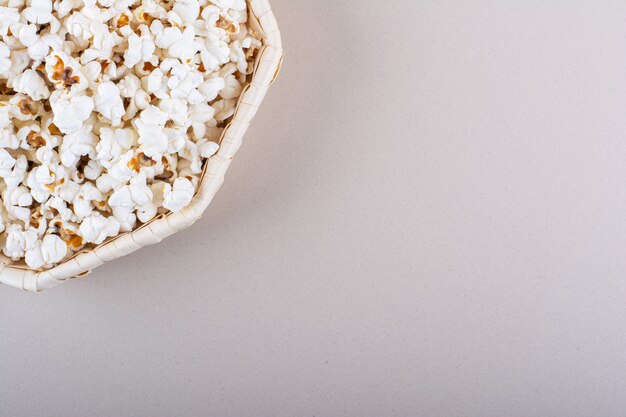 Panier en osier de pop-corn salé pour soirée cinéma sur fond blanc. photo de haute qualité