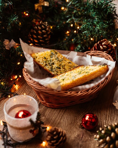 Un panier de paille avec du pain à l'ail garni d'herbes et de fromage