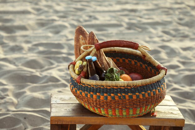 Panier de pique-nique rempli de collations et de boissons à la plage