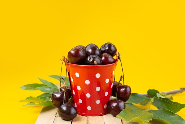 Un panier vue de face avec des cerises aigres et moelleuses sur jaune, couleur fruit aigre