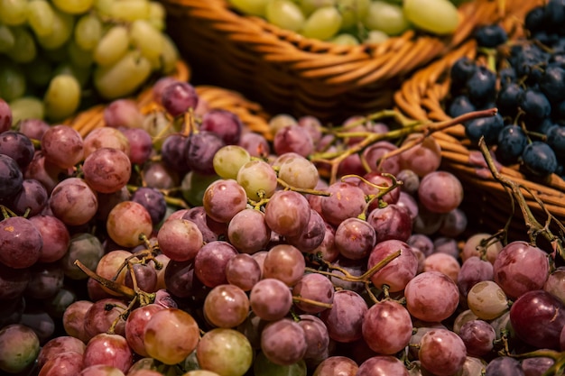 Photo gratuite paniers avec différents types de raisins sur une vitrine de supermarché