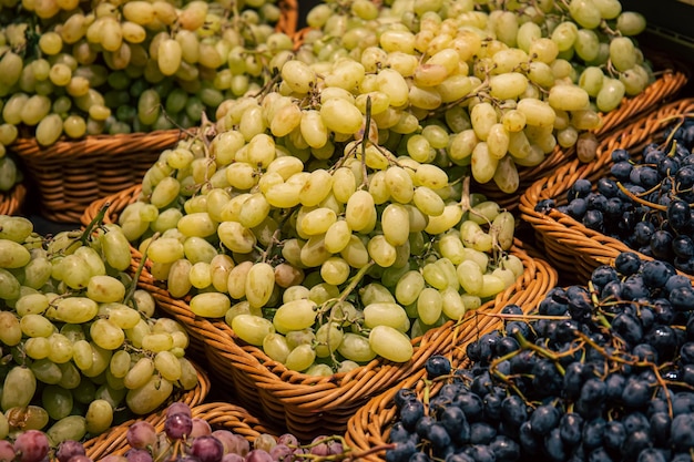 Photo gratuite paniers avec différents types de raisins sur une vitrine de supermarché