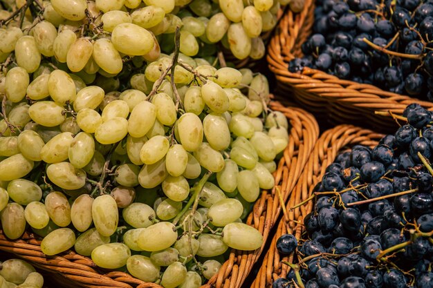 Paniers avec différents types de raisins sur une vitrine de supermarché