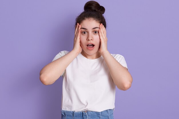 Panique femme avec sa bouche ouverte debout isolé sur mur lilas