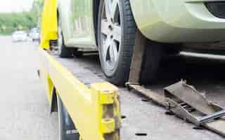 Photo gratuite panne de camion transporteur pendant le travail utilisant un transporteur à ceinture verrouillée autre voiture verte