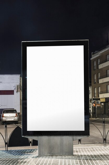 Panneau d&#39;affichage blanc vide sur la rue de la ville la nuit