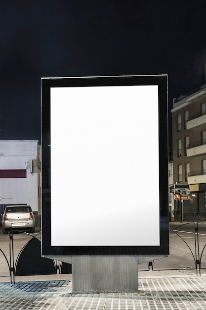 Panneau d&#39;affichage blanc vide sur la rue de la ville la nuit